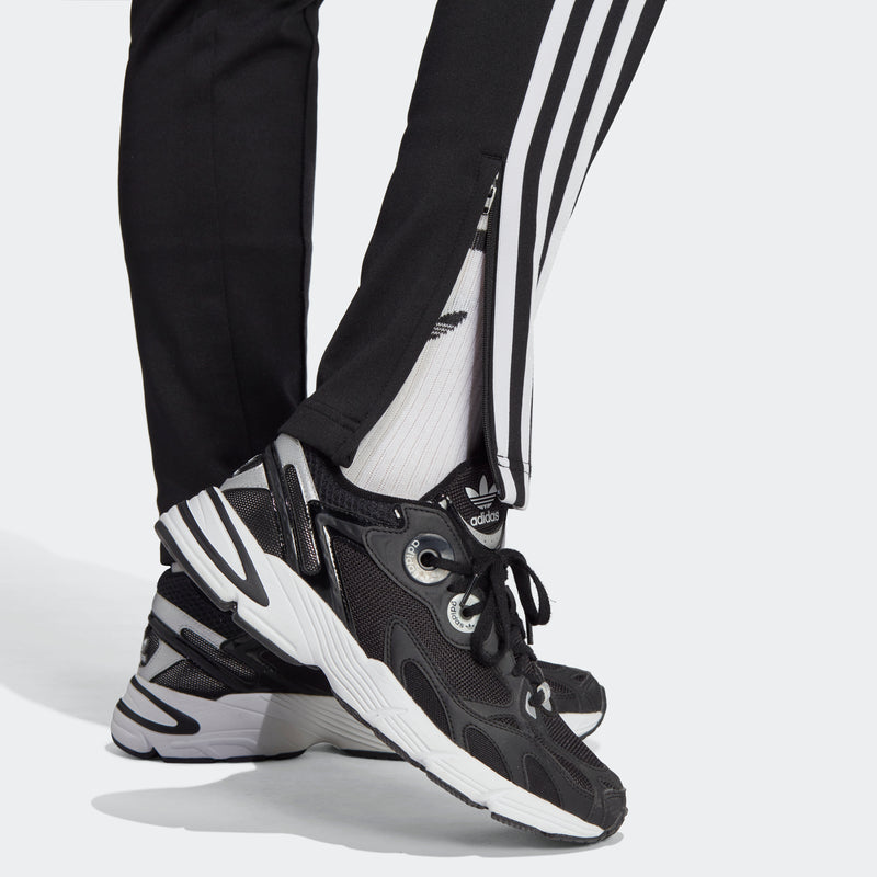 Women's black track pants with white triple stripes near hem, adidas logo