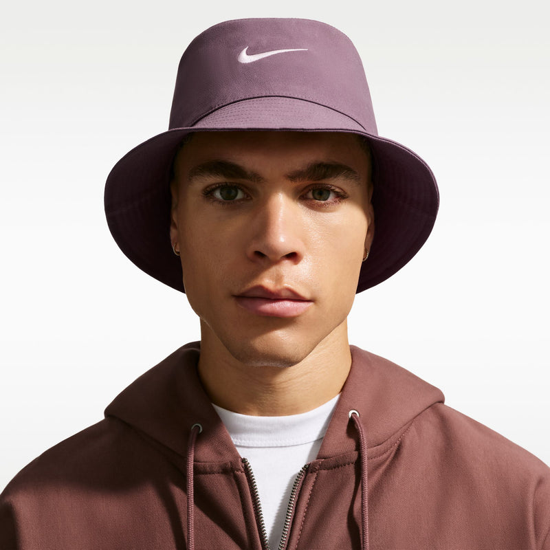 Mauve bucket hat with white Nike Swoosh, wide brim