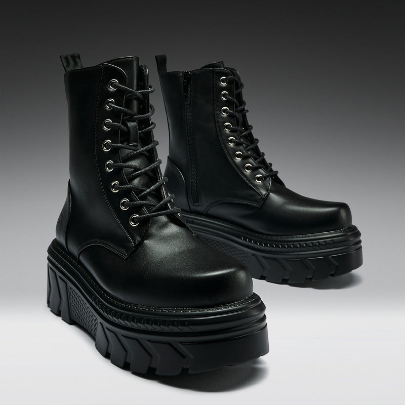 Pair of black leather boots with thick soles on a gradient background