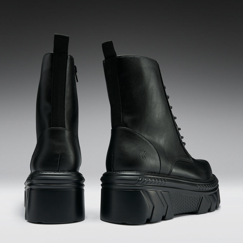 Black leather boots on a gradient gray background