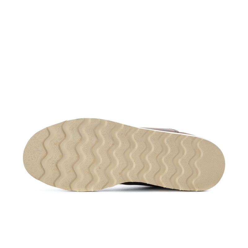 Outsole of women’s wide Chelsea boots with wavy tread, light rubber color