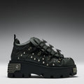 Black studded sneaker on a gray background