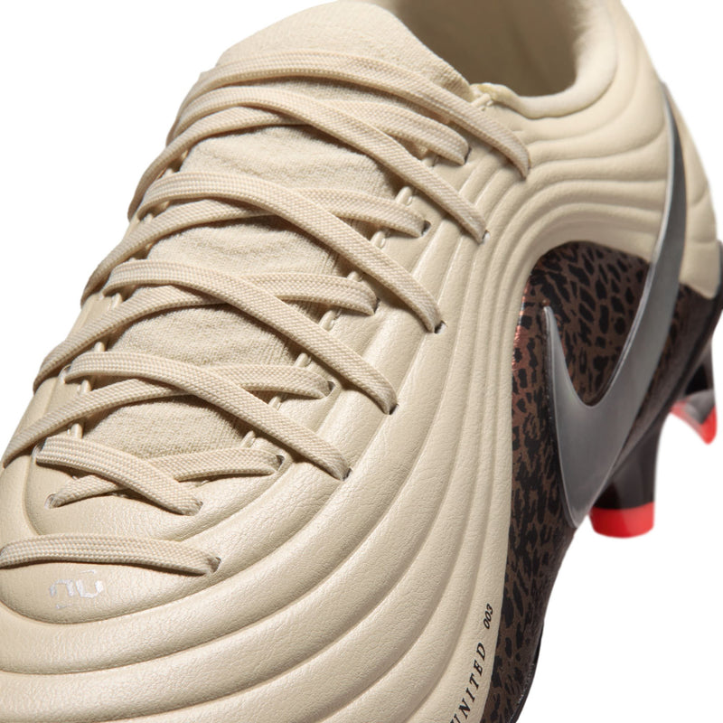 Close-up of men's cream soccer cleat laces and textured collar with red outsole detail