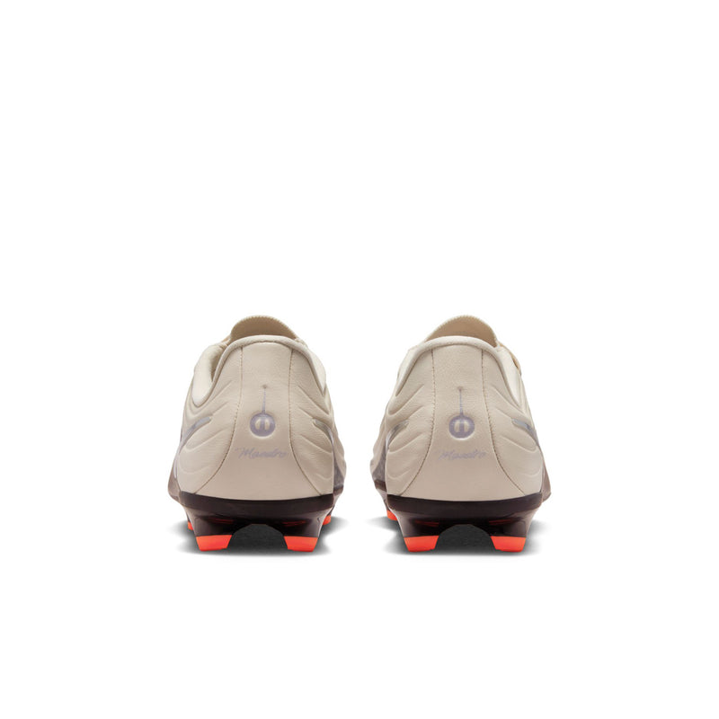 Youth soccer cleats from heel view: cream uppers with orange-tipped outsole studs
