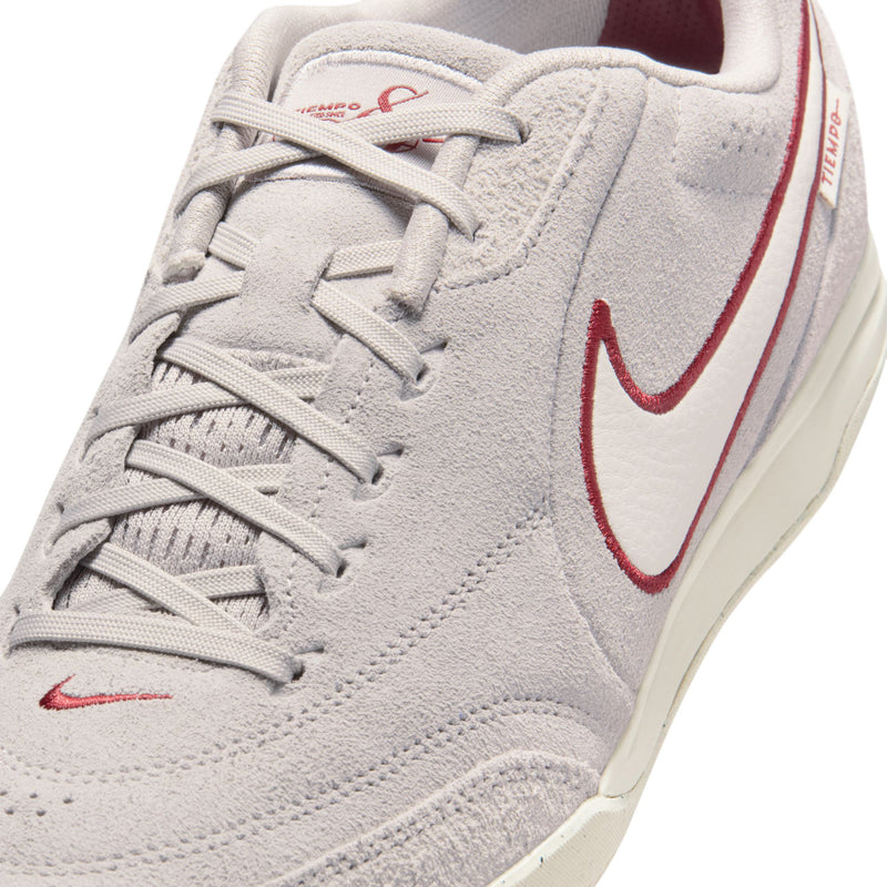 Men's lace-up sneakers close-up, gray suede with red swoosh and padded collar