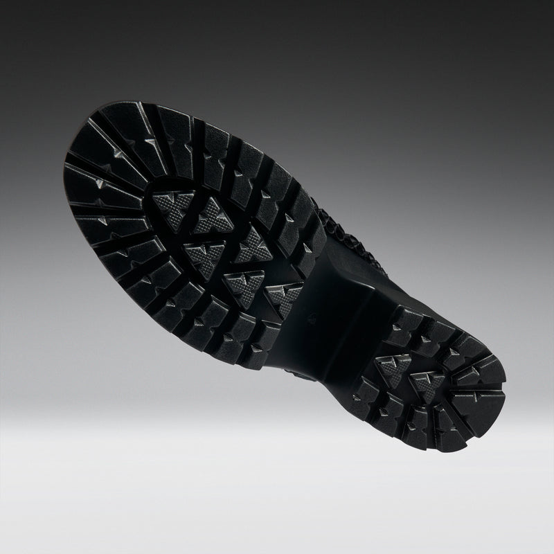 Close-up of a black mary janes sole on a gradient background