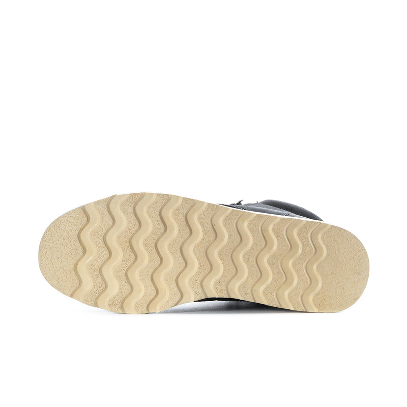 Boot outsole tread with beige rubber bottom on black high-top boot