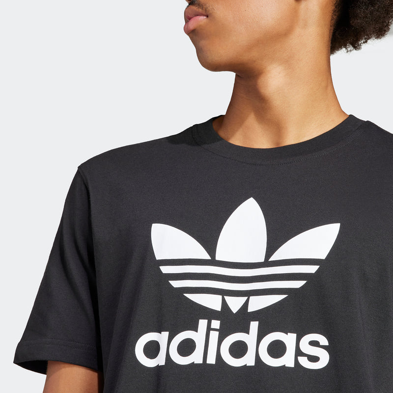 Men's black T-shirt close-up: white adidas trefoil and wordmark front print