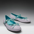 Pair of glittery shoes with light blue bows on a gradient background