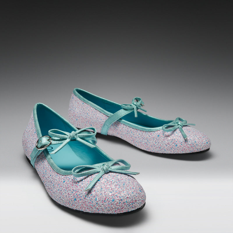 Pair of glittery shoes with light blue bows on a gradient background