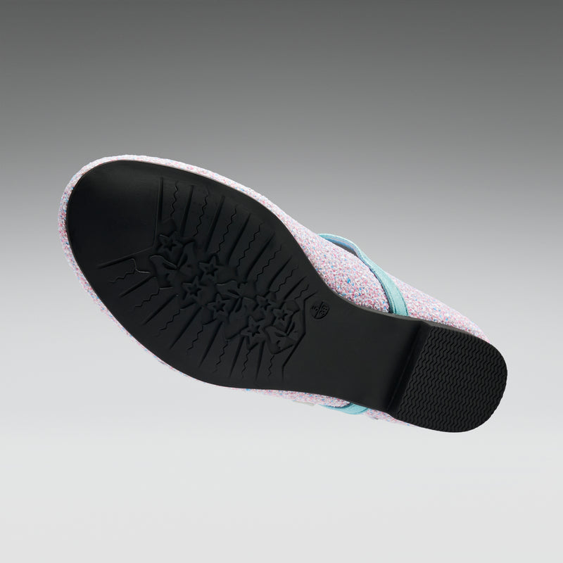 Close-up of a sandal sole with textured black rubber and light purple fabric on a gray background