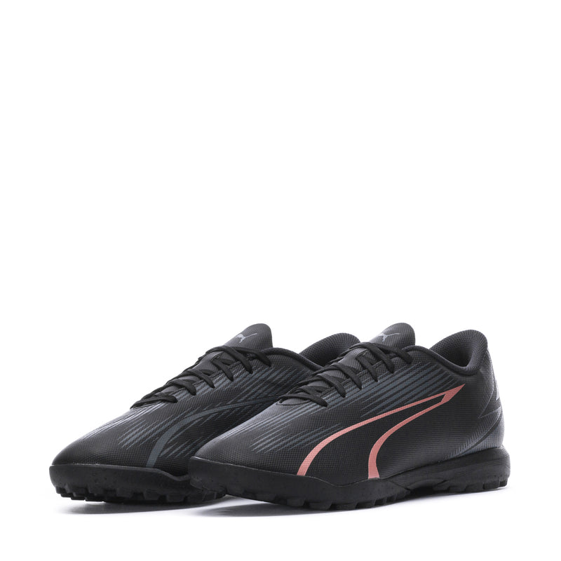 Men's Puma turf soccer shoes, black with copper-pink stripe, two shoes angled view.