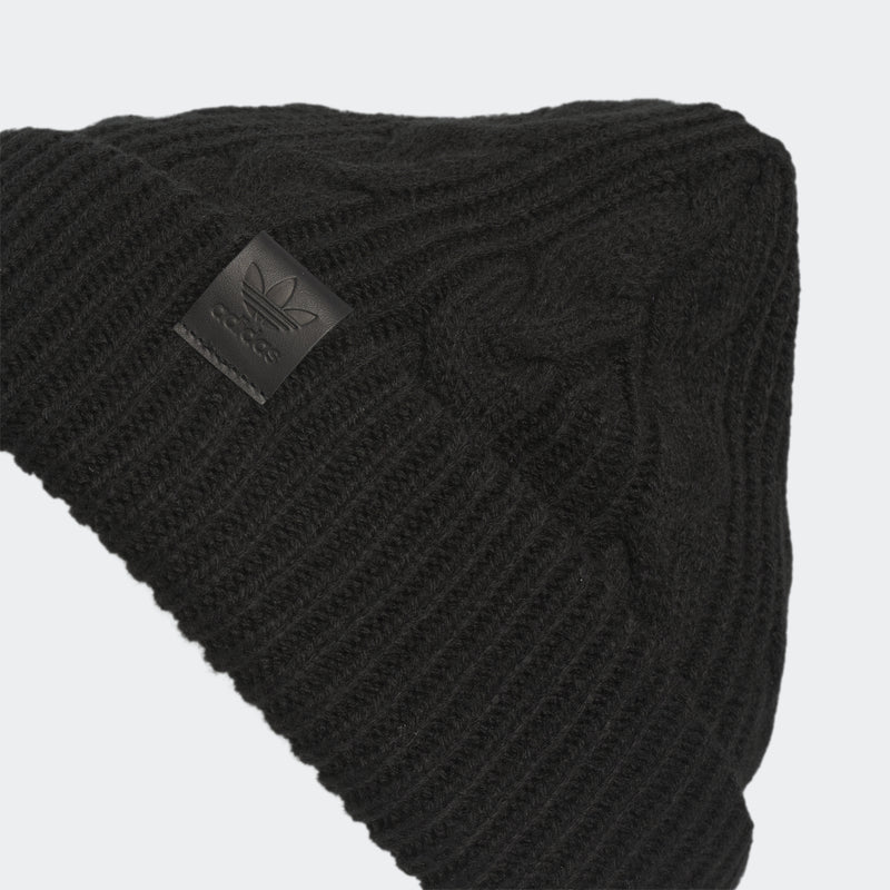 Black cable-knit beanie with embossed logo patch and detailed cable stitching.