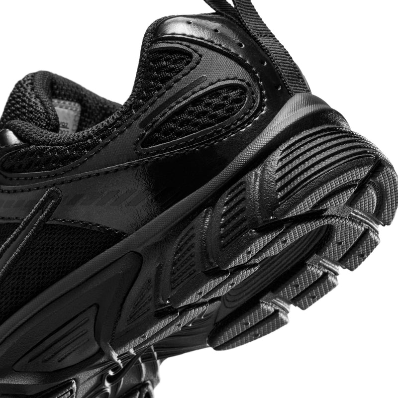 Close-up of kids black running shoe side with ridged midsole and outsole traction