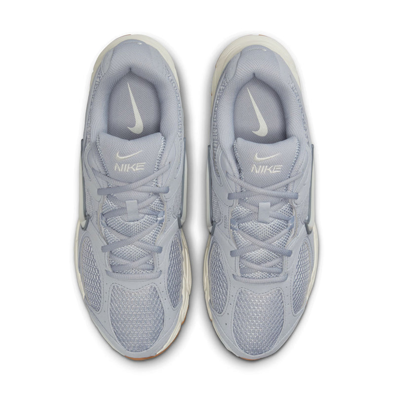 Pair of light gray running shoes, top view with laces and Nike logo on insides