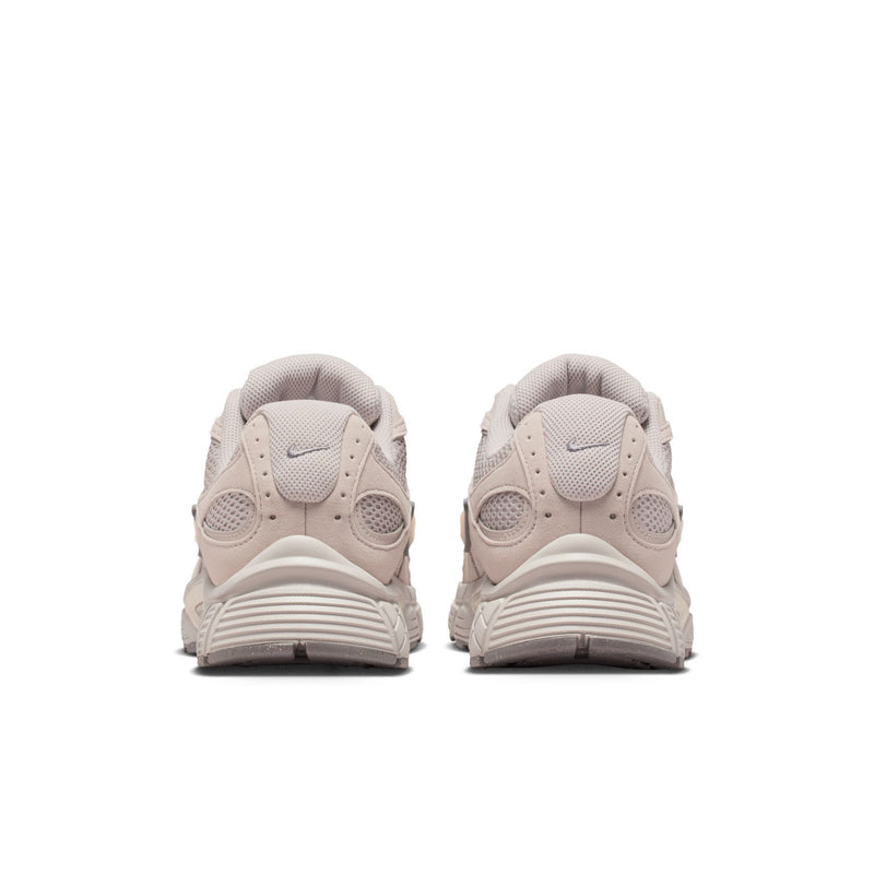 Men's beige Nike lace-up running shoes, heel view with rubber pods on outsole.
