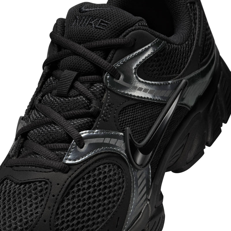 Men's black sneaker close-up with black laces, silver trim, and Nike Swoosh