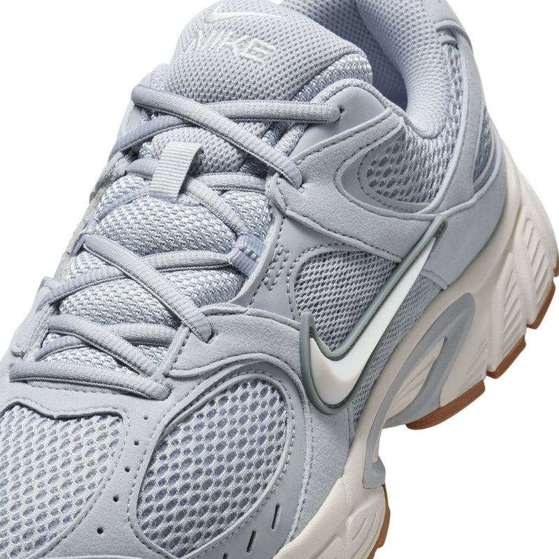 Close-up of light gray running shoe upper with laces, mesh panels, and Nike swoosh