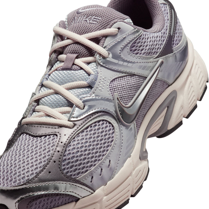 Nike lace-up running sneaker close-up, gray mesh with swoosh logo and padded collar