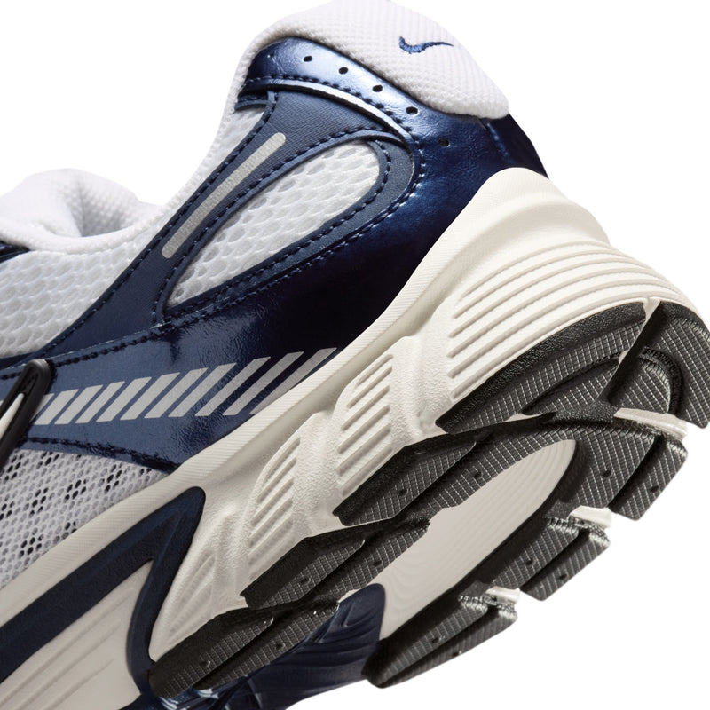 Close-up of navy and white sneaker heel and outsole tread with side logo