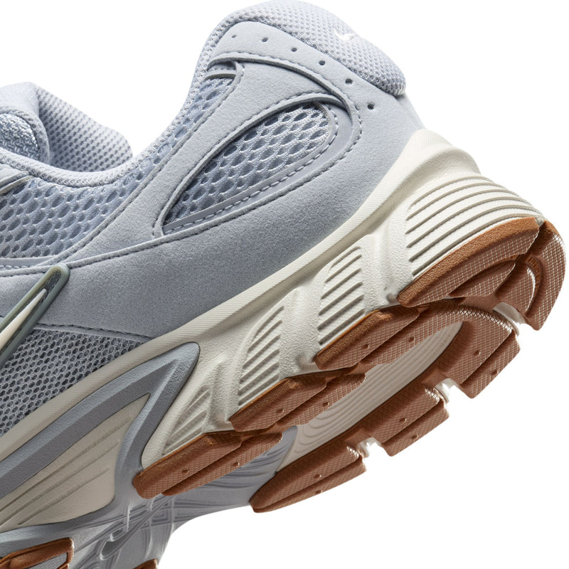 Close-up of light gray running shoe sole with stacked tread and gum-brown edge accents