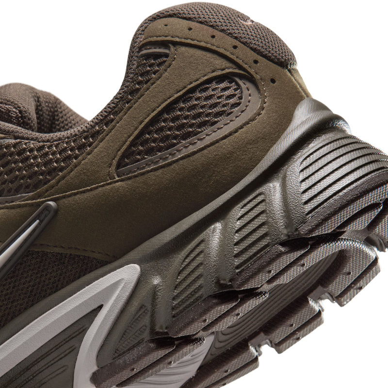 Close-up of olive-brown sneaker midsole with white traction pods