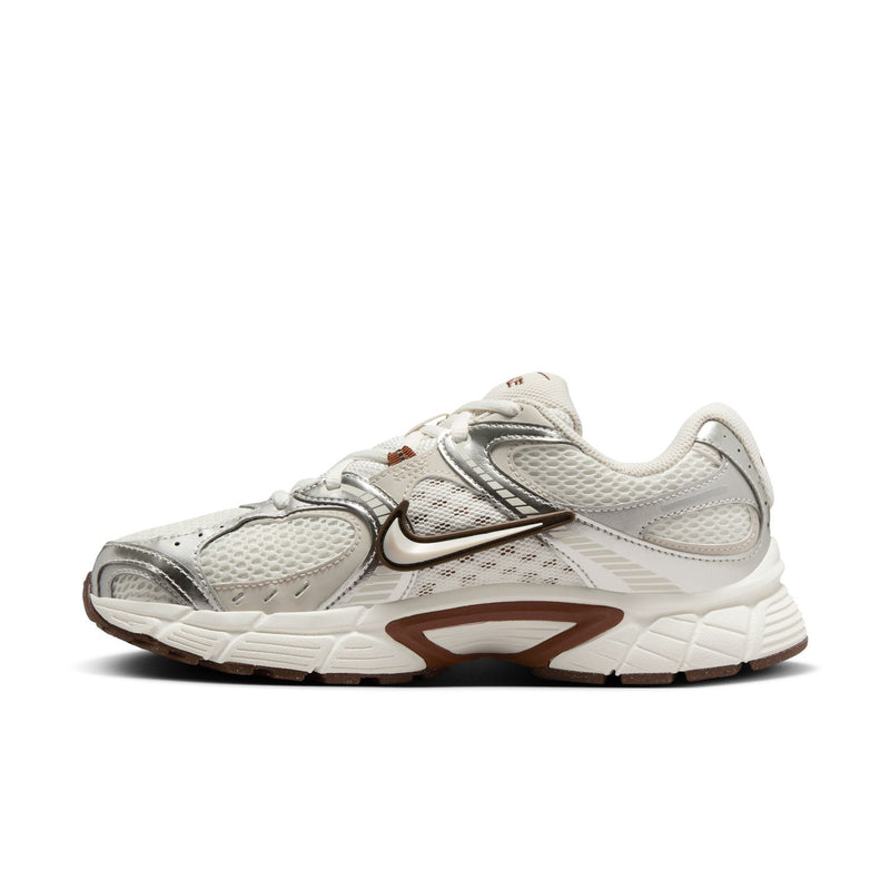 White Nike running sneakers, angled side view with swoosh and brown panel accents.