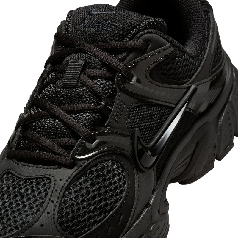 Women's black running shoe close-up of laces, mesh texture, and swoosh logo