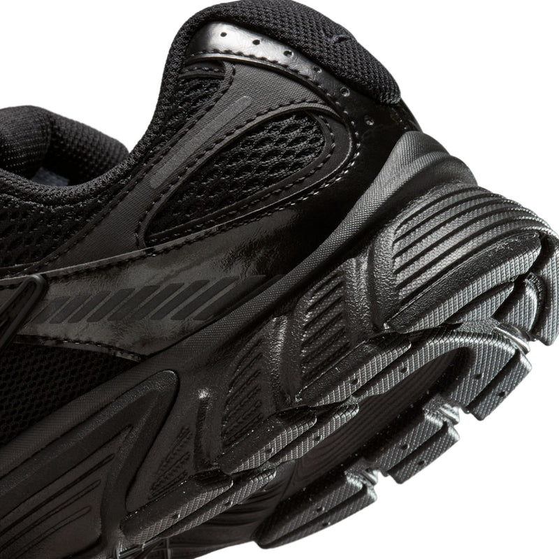 Women's black running shoe close-up of side texture, stripes, and lace overlay