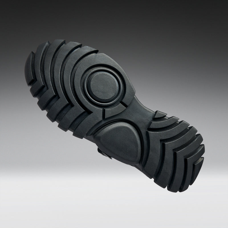 Close-up of a black rubber sole on a gradient background