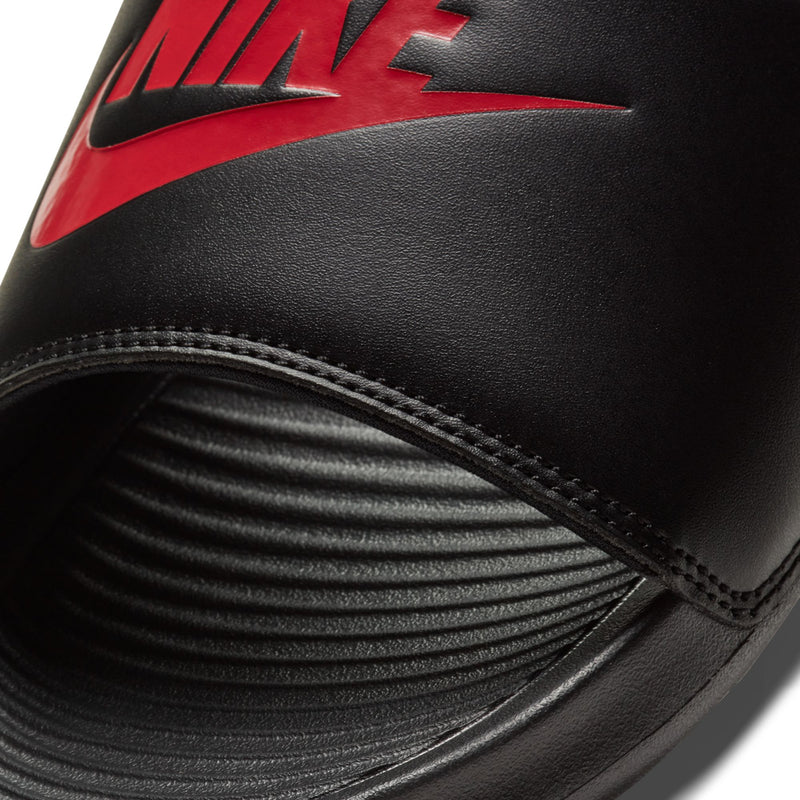 Close-up of black slide sandal strap with red Nike logo and stitched edge