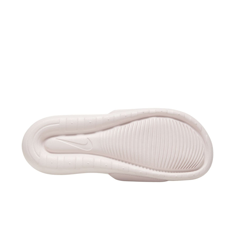 Women's Nike slide sandal outsole view with textured light-pink footbed
