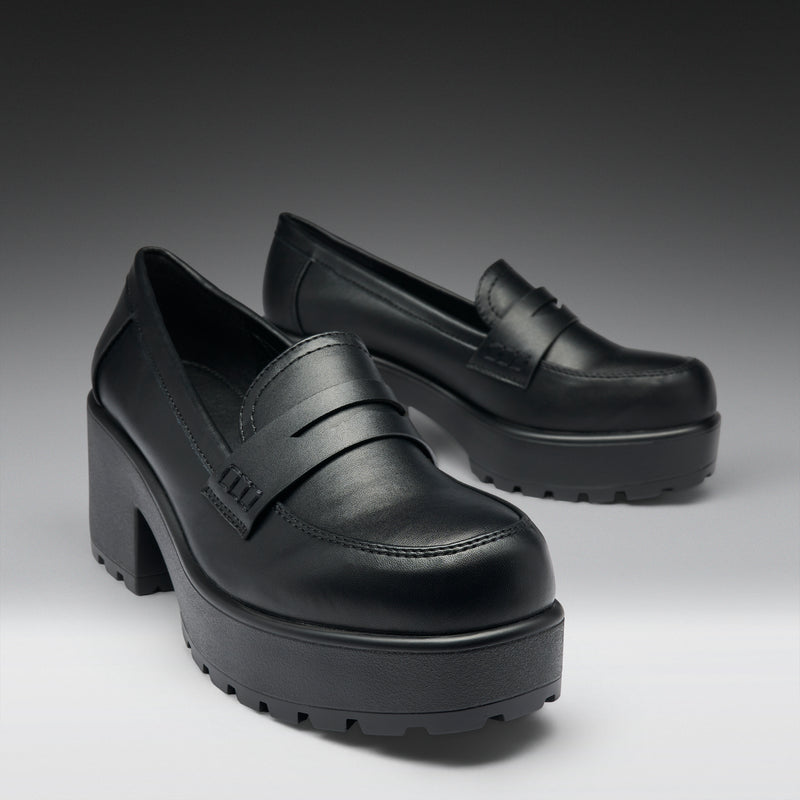 Black platform shoes on a gradient gray background