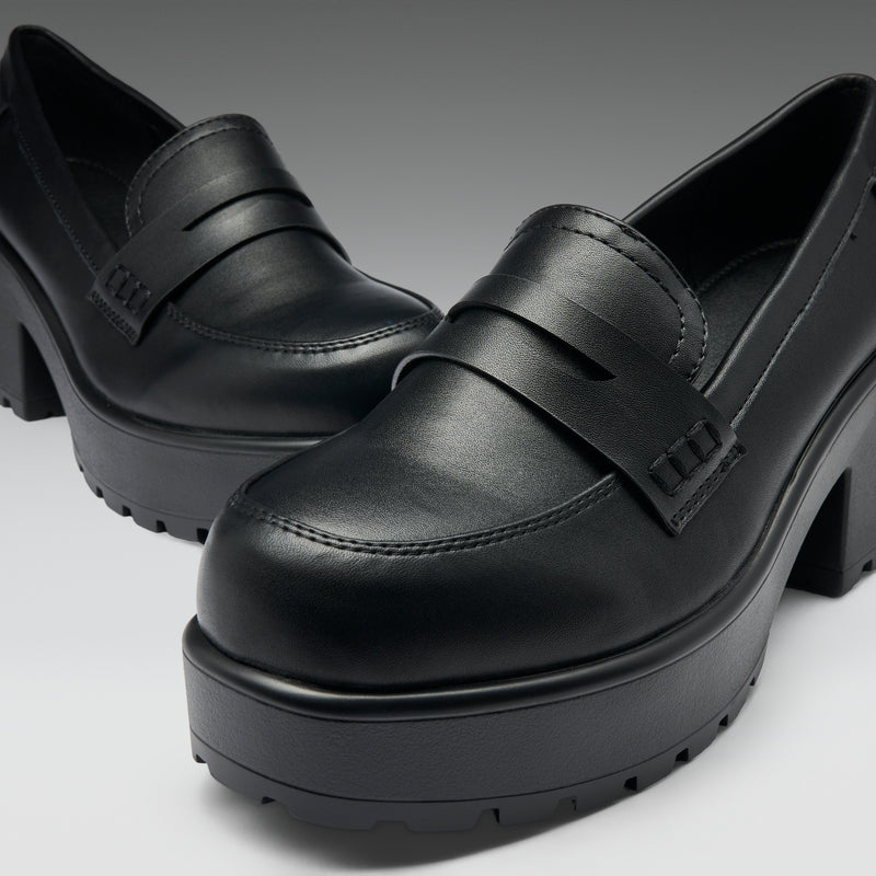 Black platform shoes on a light gray background