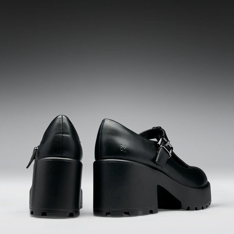 Black platform shoes on a gray background