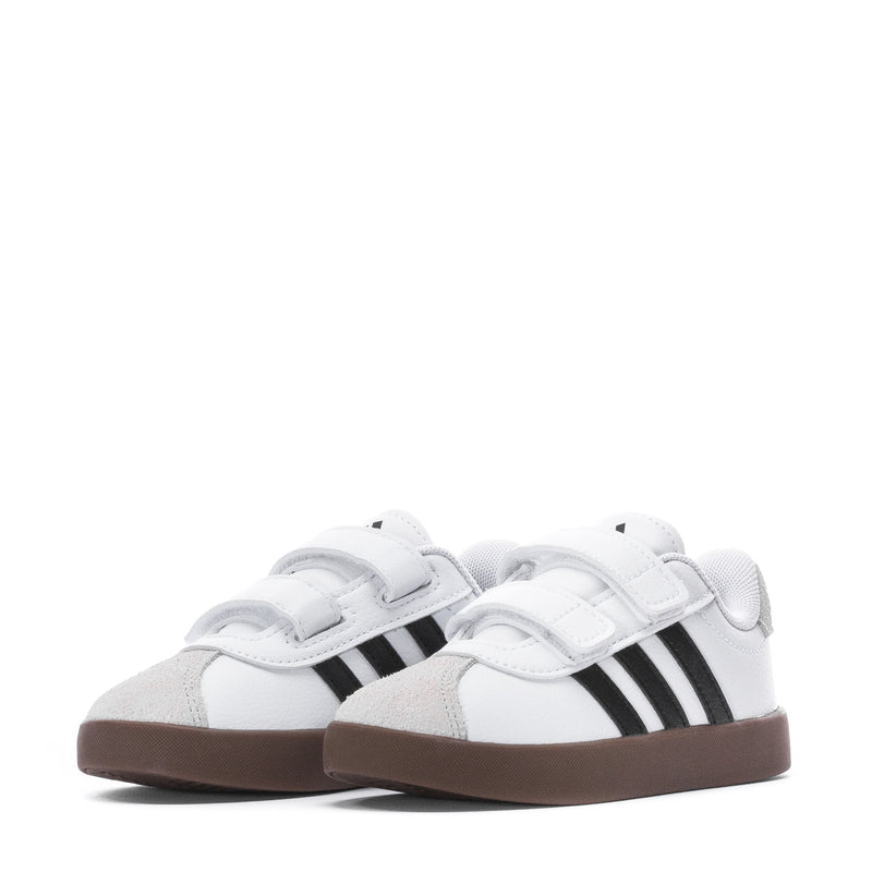 Pair of white toddler sneakers with two black stripes and Velcro straps, brown sole