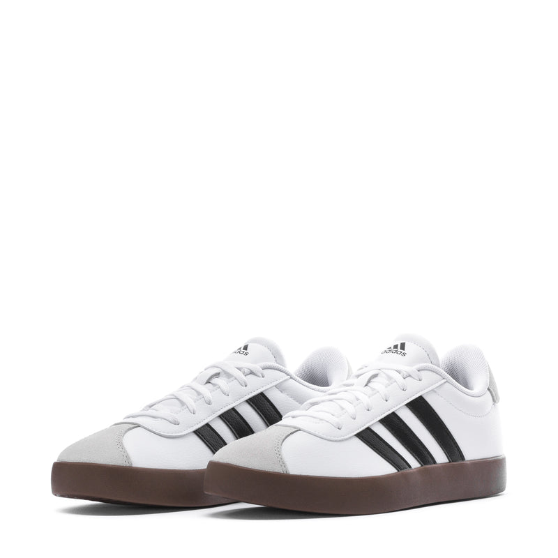 Youth adidas sneakers, front close-up: white upper, black stripes, gum sole