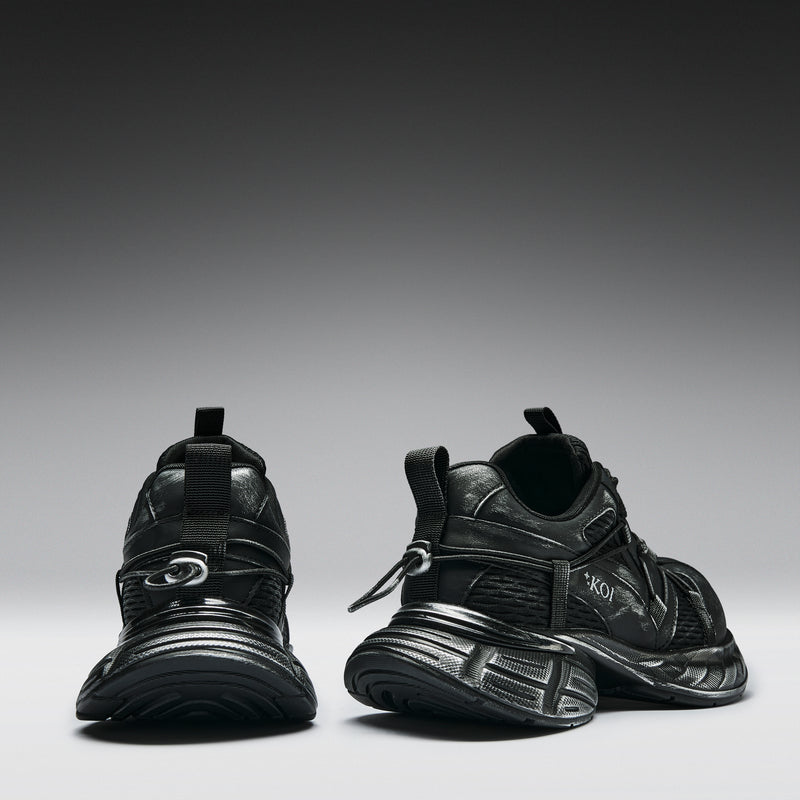 Pair of black sneakers on a gradient gray background