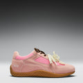 Pink shoe with brown sole on a gray background