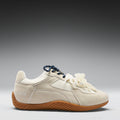 White sneaker with brown sole on a gray background