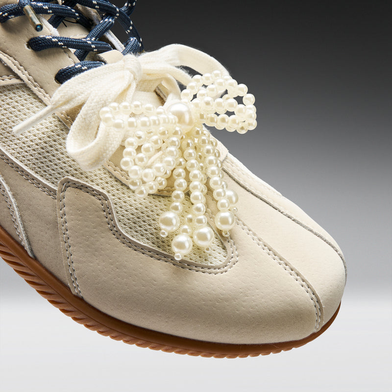 Beige sneaker with pearl-laced shoelaces on a gradient background