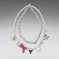 Necklace with various charms on a gray background