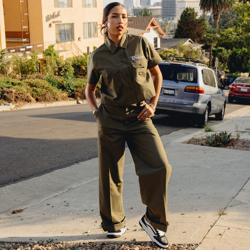 Women’s wide-leg military green pants with belt loops and front pockets, side view.