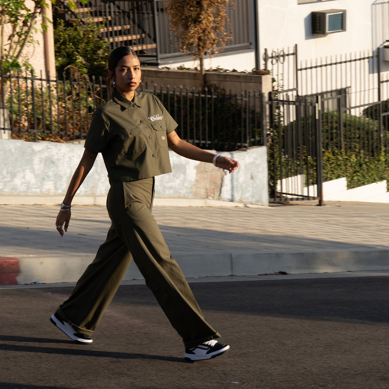 Women’s wide-leg military green pants with belt loops, relaxed straight legs, walking view.