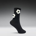 Black sock with white flower patterns on a gray background