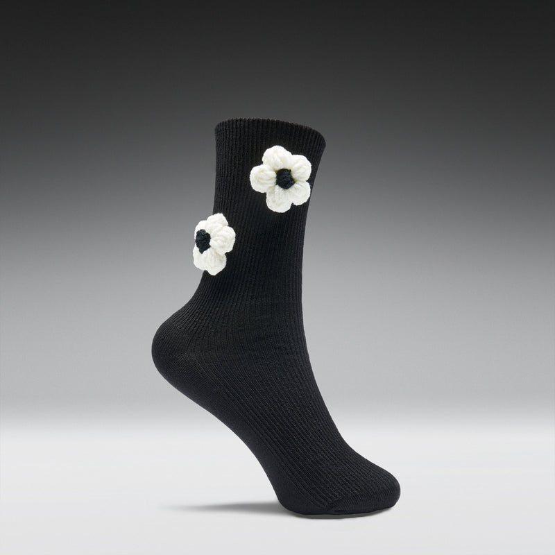Black sock with white flower patterns on a gray background
