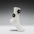White sock with black flower decorations on a gray background