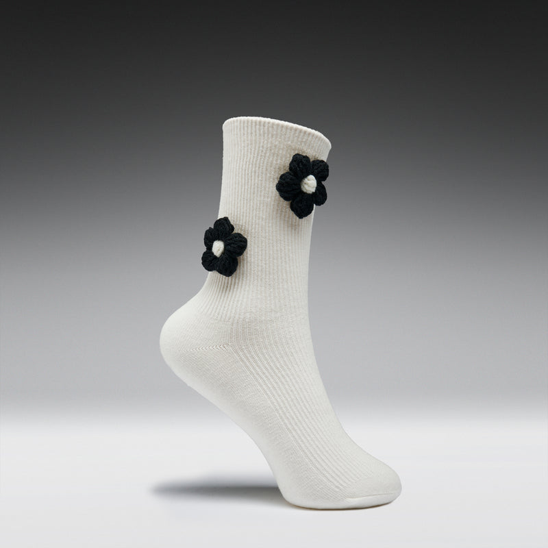 White sock with black flower decorations on a gray background