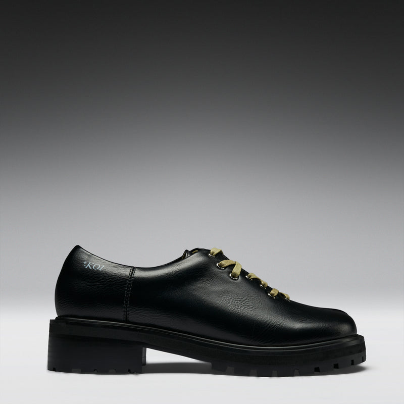 Black leather shoe on a gray background
