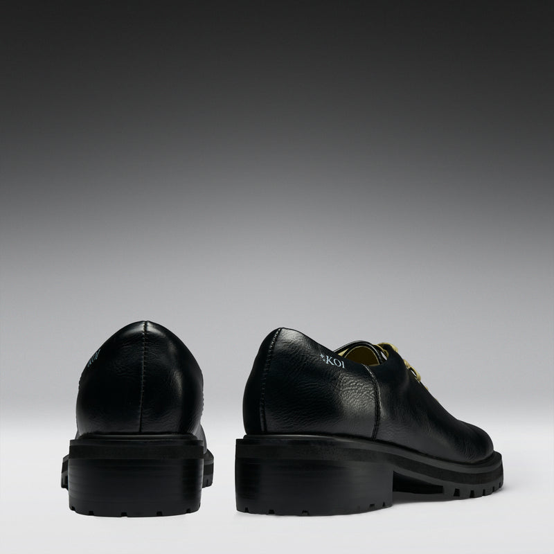 Black leather shoes on a gradient gray background